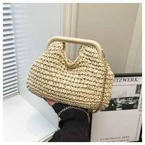 Détail d'un sac à main en paille beige avec texture ondulée et chaîne dorée fine