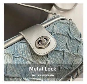 Detailed macro of the silver hardware lock and metal chain on blue denim quilted bag