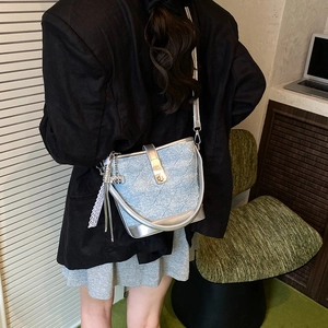 Sac seau bleu clair texturé avec charme en dentelle et bordure argentée sur mannequin