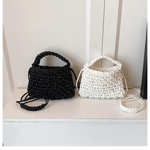 Gros plan sur la texture tissée main et la bandoulière des sacs design noir et blanc