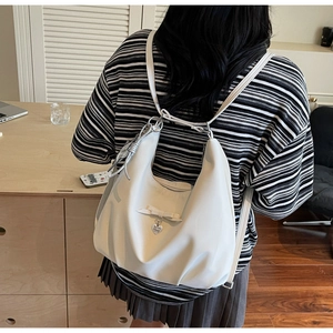 Rear view of white fashion backpack with bow and heart pendant on model back