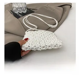 Détails de la texture tissée du sac blanc avec fine bandoulière et nœuds décoratifs