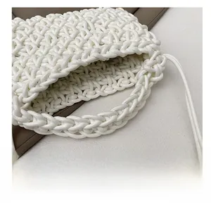 Détail du sac tissé main blanc crème montrant la texture crochet et l'anse épaisse