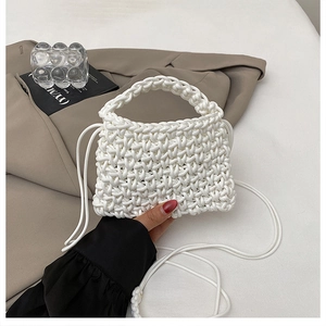 Gros plan détaillé du sac à main tissé blanc avec texture en nid d'abeille et nœuds