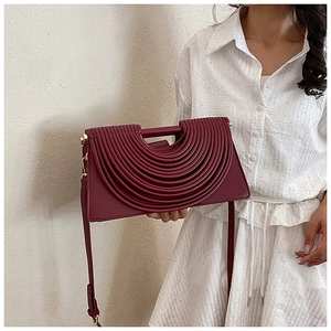 Détail du sac bandoulière bordeaux avec design plissé superposé et bandoulière fine