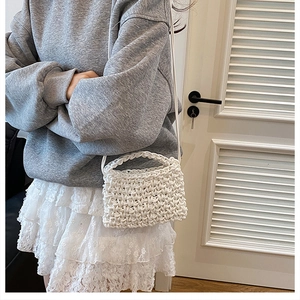 Détail d'un sac bandoulière en grosse maille blanche tissé à la main sur modèle
