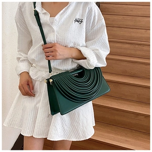 Détail du sac bandoulière vert présentant un design unique de vagues concentriques