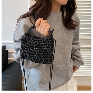 Détail d'un mini sac bandoulière noir tissé main avec texture de nœuds en corde épaisse