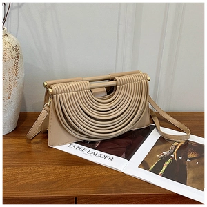 Détail du sac à bandoulière abricot avec texture plissée et poignée cylindrique chic