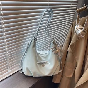 Blue hobo shoulder bag with bow and star charm shown in a sunlit window scene