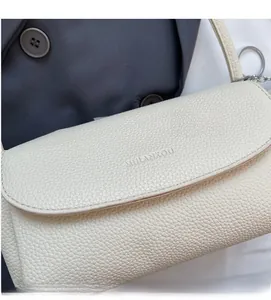 Detail of lychee pattern leather surface and silver metal hardware on underarm bag