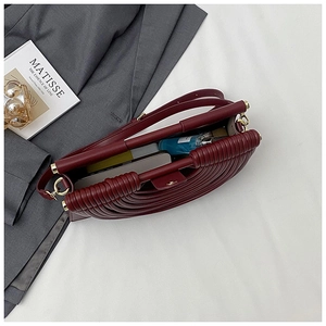 Détail de l'intérieur d'un sac accordéon bordeaux avec ferrures dorées et accessoires