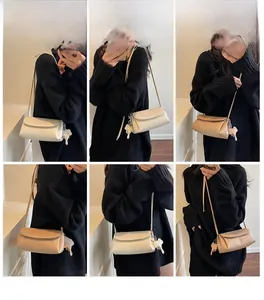 Detail view of stylish underarm bags in white and khaki with elephant charms