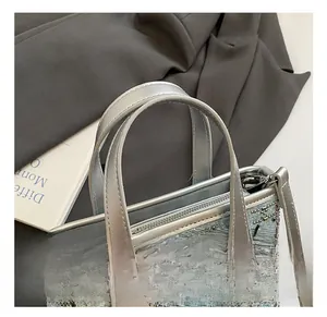 Detailed shot of blue denim bucket bag with silver rhinestones and studded diamond patterns