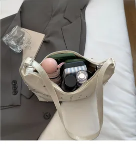 Spacious interior of studded cream hobo bag showing umbrella and phone storage capacity