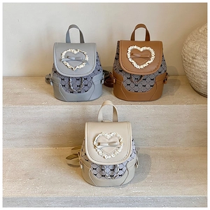 Detailed view of mini backpacks with bow accents and heart-shaped lace in three colors