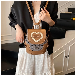Detailed shot of bow-knot mini backpack with heart lace and floral fabric splicing