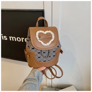 Détails d'un mini sac à dos avec nœud papillon, dentelle en cœur et tissu à carreaux