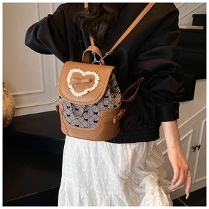 Détail du sac à dos vintage avec nœuds, bordure dentelle cœur et tissu à carreaux