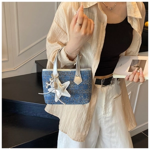 Detail of blue denim mini tote with silver handles and sparkling star pendant charms