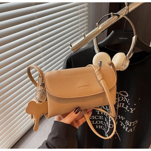 Detail of khaki litchi grain leather bag with elephant charm and MULANKOU logo