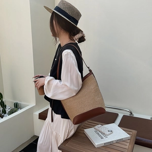 Straw woven tote bag with brown leather trim and shoulder straps for summer style