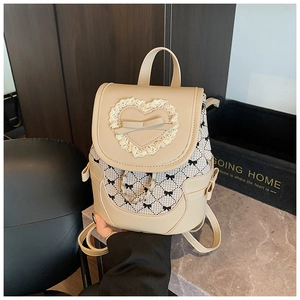 Close-up of beige leather backpack with lace heart and black gingham bow patterns