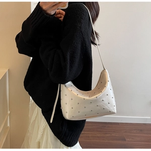 Silver leather hobo bag with metal rivets shown on model for a trendy summer look
