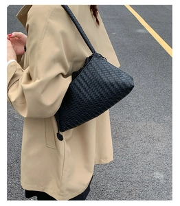 Close-up of black woven shoulder bag showing fine craftsmanship and draw-string inner pouch