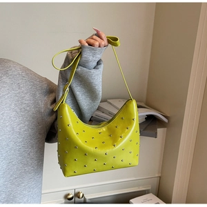 Detail view of lime green hobo bag featuring silver studs and adjustable shoulder strap