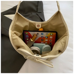 Interior view of off-white tote bag showing large capacity for tablet and cosmetics