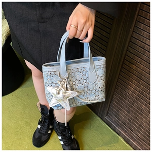 Detail of light blue bucket bag with silver rhinestone grid and star bag charm
