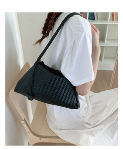 Detail of a black woven shoulder bag showing tight texture and premium craftsmanship