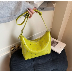 Detailed view of neon green rivet shoulder bag featuring silver studs and smooth zipper