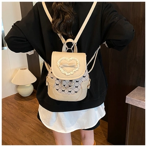 Détail d'un mini sac à dos beige avec dentelle cœur, nœuds et motif floral rétro imprimé