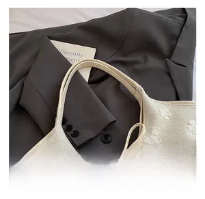 Close-up of woven bucket bag featuring 3D floral accents and elegant bow details