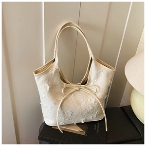 Close-up of white floral tote bag with 3D flower patches and a delicate bow detail