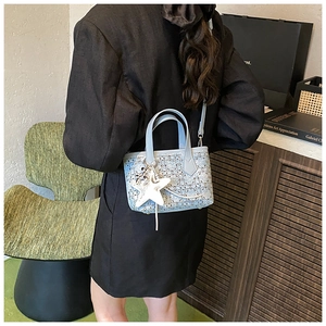 Blue tweed bucket bag featuring leather handles and a white star charm on a crossbody strap