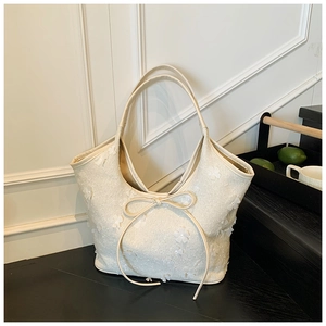 Close-up of cream floral tote bag with 3D flower appliques and bow detail