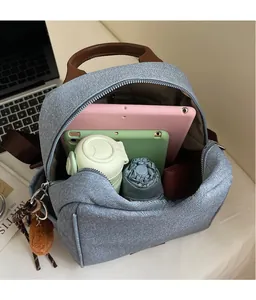 Macro detail of spacious denim backpack interior with tablet, umbrella and leather handle