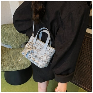 Close-up of light blue cannage pattern crossbody bag with silver star charm