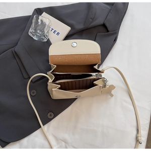 Detail view of cream white leather bag interior with double compartments and magnetic closure