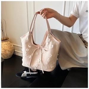 Close-up of pink canvas tote bag with 3D floral patches and soft ribbon bow details