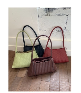 Detail of woven tote bags in green, black, burgundy, and brown with drawstring closure
