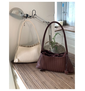 Detail of woven tote bags in beige and brown with drawstring lining and texture
