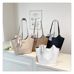 Detail view of large tote bags in four colors with decorative silk scarves and lychee texture