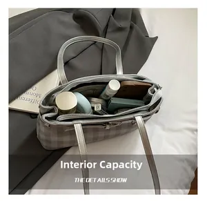 Detailed interior of silver checkered baguette bag showing large storage capacity