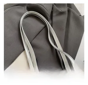 Detail of silver-grey tote bag showing twin flat handles and metallic buckle on lychee texture