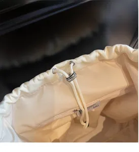 Detailed macro view of the cream canvas bag drawstring closure with metal eyelets