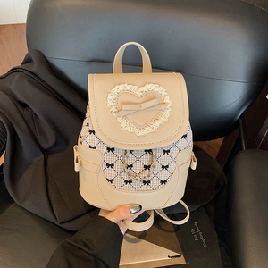 Sac à dos beige chic avec dentelle coeur et motif à carreaux sur un fauteuil en cuir